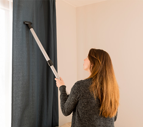 En La Araña ofrecemos el mejor lavado de cortinas en Bogotá Mujer realizando el lavado de cortinas en Bogotá